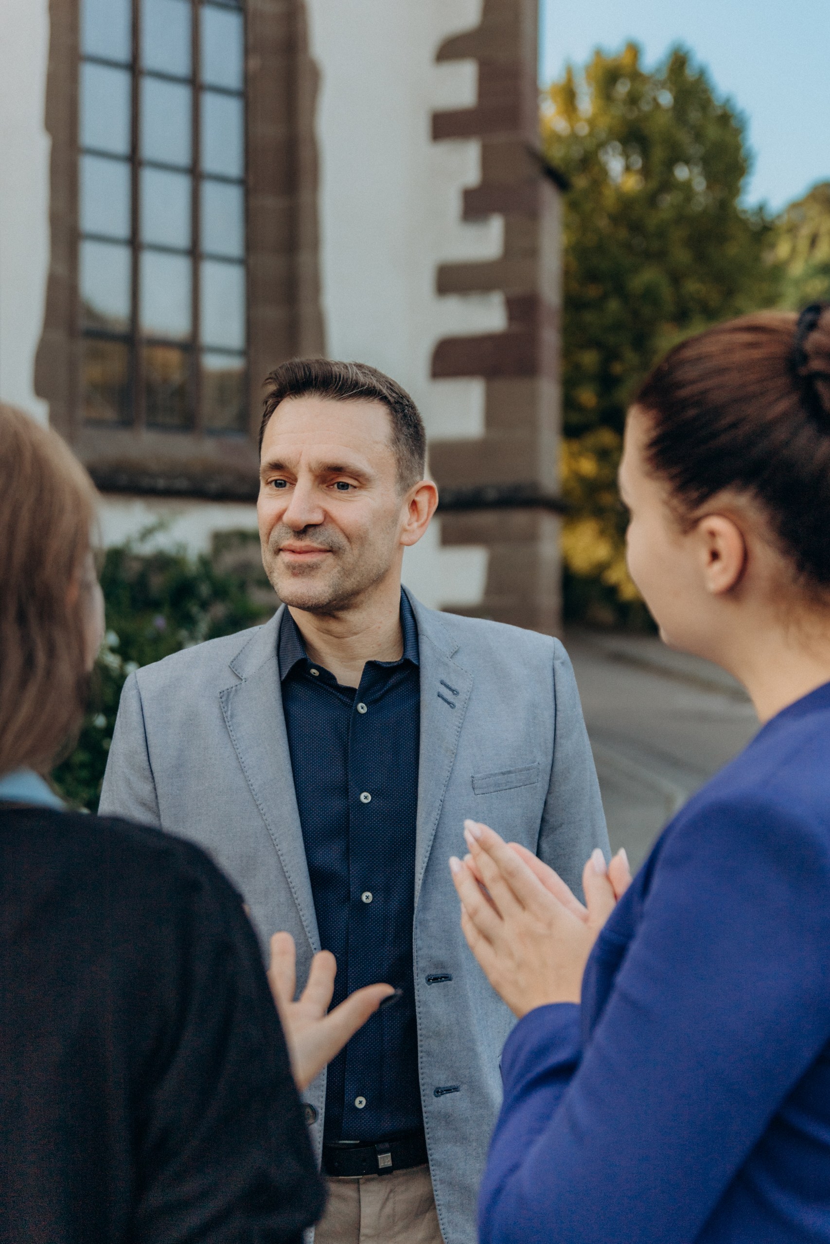 Frank Geiger im Gespräch mit zwei Bürgerinnen vor der Kirche
