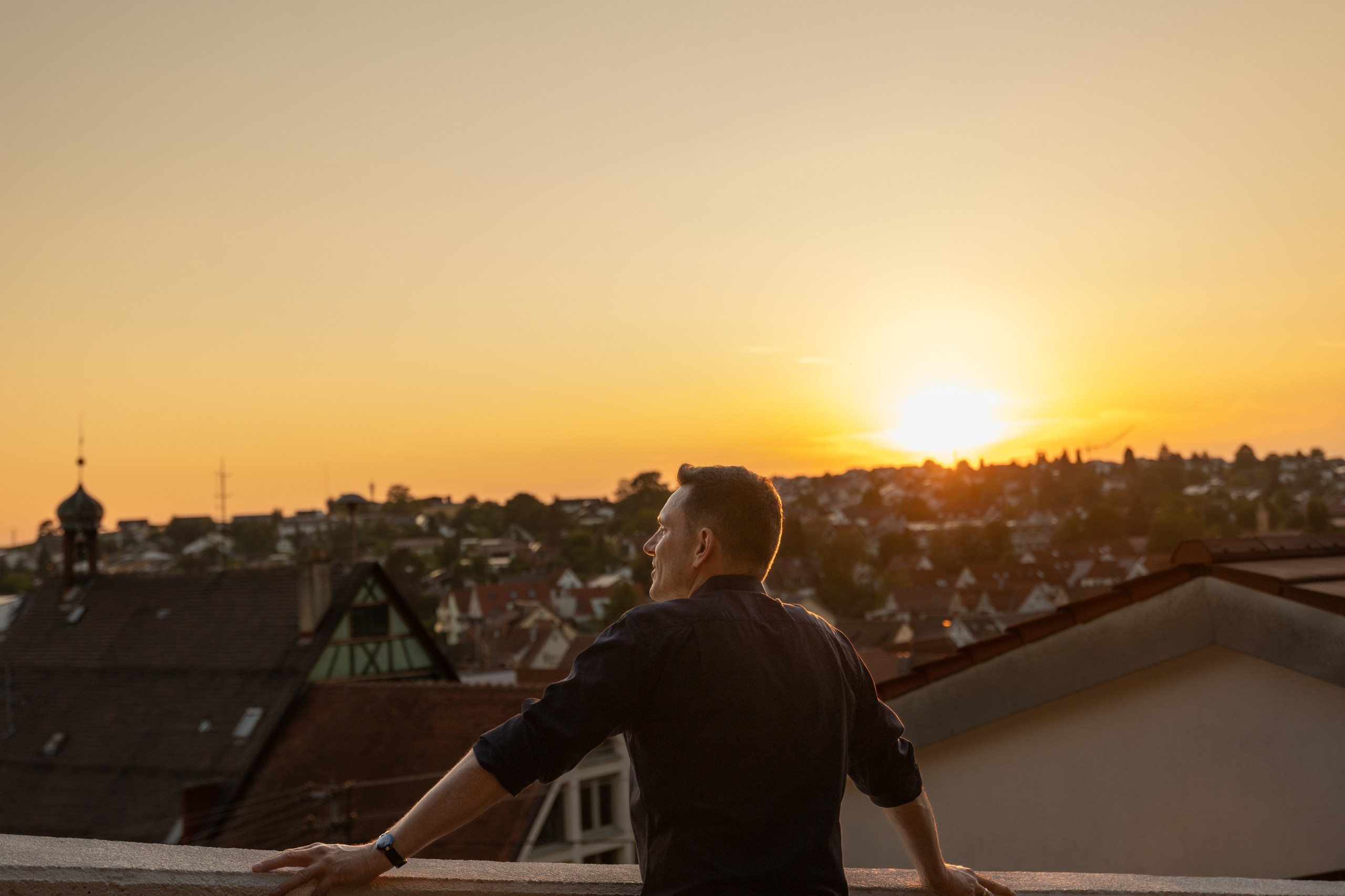 Frank Geiger blickt bei Sonnenuntergang über die Dächer von Beilstein